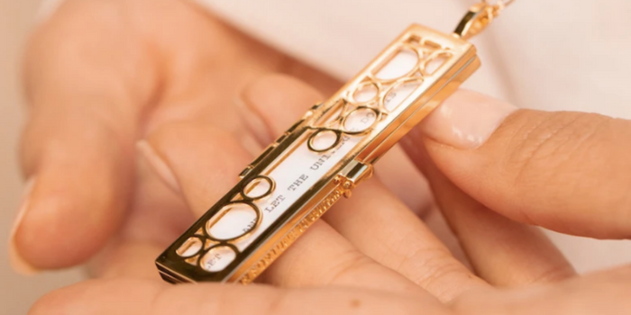 Hands holding a Fortune & Frame Cascading Circles Fortune Locket.